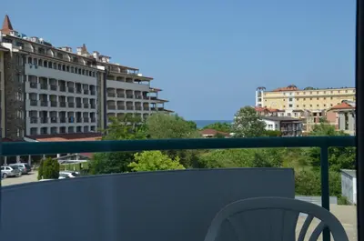a balcony with a chair and a view of a city at Sania in Obzor