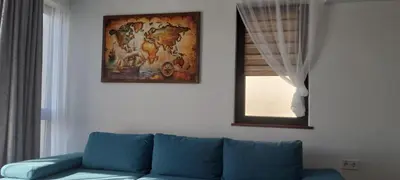 a blue couch in a living room with a picture on the wall at Anthic 7 Apartment 3 in Sozopol