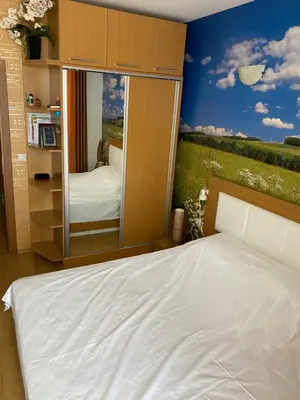 a bedroom with a bed and a large mirror at Апартамент на солнечном берегу in Sunny Beach