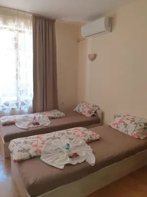 two beds sitting in a room with a window at Hotel Royal Dreams Privat Apartment in Sunny Beach