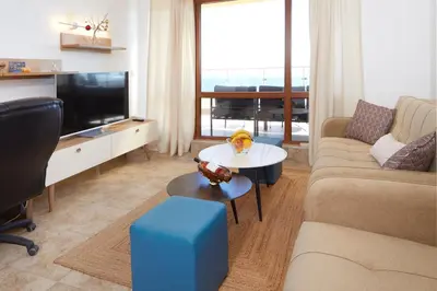 a living room with a couch and a tv at Infinity Terrace 1BR Apartment Nessebar in Nesebar