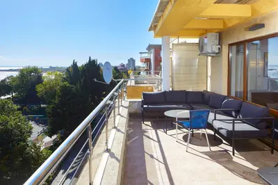 a balcony with couches and a table and chairs at Infinity Terrace 1BR Apartment Nessebar in Nesebar
