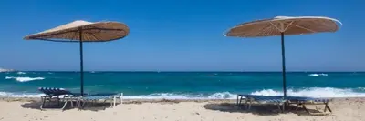 a group of chairs and umbrellas on a beach at Guest Rooms Nia Elis Kiten in Burgas City