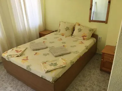 a small bedroom with a bed with flowers on it at Guest Rooms Nia Elis Kiten in Burgas City