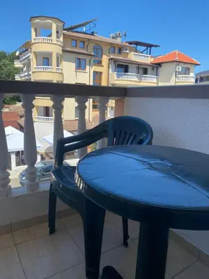 a blue table and chair on a balcony with a building at Guest Rooms Nia Elis Kiten in Burgas City