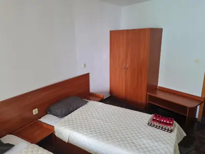 a small bedroom with a bed and a cabinet at Алми Almi in Sveti Vlas