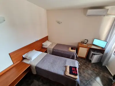 a room with two beds and a desk with a computer at Алми Almi in Sveti Vlas