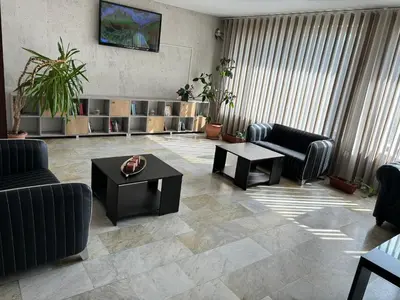 a living room with couches and tables and plants at Relax Guest House in Burgas City