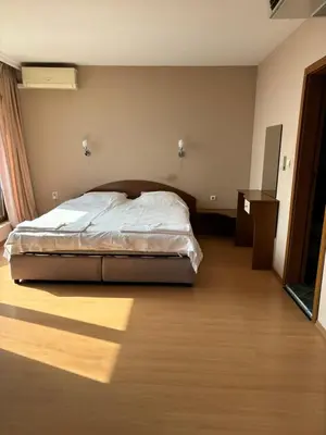 a bedroom with a bed and a wooden floor at Relax Guest House in Burgas City