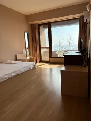 a hotel room with a bed and a large window at Relax Guest House in Burgas City