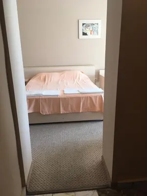 a small bedroom with a bed with pink sheets at Relax Guest House in Burgas City