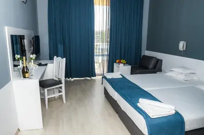 a hotel room with a bed and a desk and a chair at Sun Palace Hotel - All Inclusive in Sunny Beach
