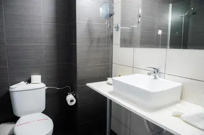 a bathroom with a sink and a toilet and a mirror at Sun Palace Hotel - All Inclusive in Sunny Beach
