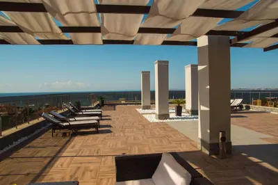 a patio with chairs and tables on a roof at Луксозен апартамент Свети Влас Вила Аристо in Sveti Vlas