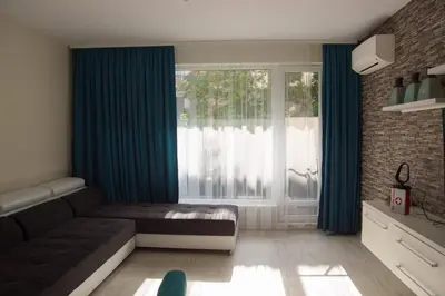 a living room with a couch and a large window at Луксозен апартамент Свети Влас Вила Аристо in Sveti Vlas