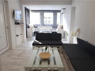 a living room with a black couch and a table at Top Center 4-Bedroom Apartment in Varna City