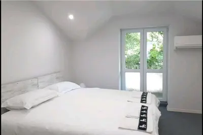 a bedroom with a white bed with a window at Top Center 4-Bedroom Apartment in Varna City