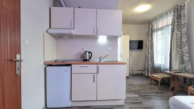 a kitchen with white cabinets in a room at Compact studio with an indoor pool near Cacao Beach by Flаt Manаger in Sunny Beach