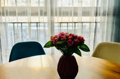 a vase of roses sitting on top of a table at Luxury Apartment Azure Coast Panorama in Burgas City