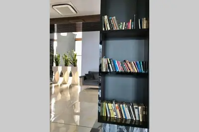 a book shelf filled with books in a living room at Luxury Apartment Azure Coast Panorama in Burgas City