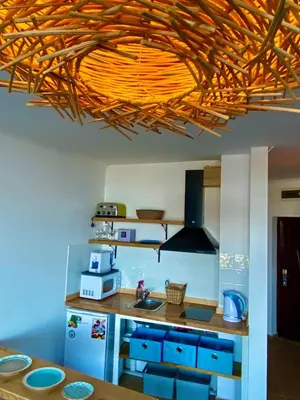 a kitchen with a wooden ceiling with a light fixture at Свети Зосим in Sozopol