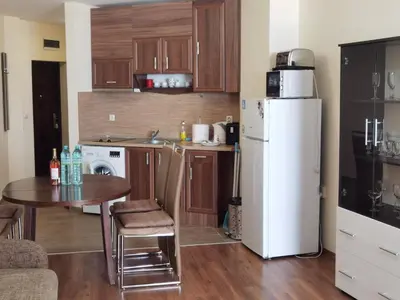 a kitchen with a table and a white refrigerator at Свети Зосим in Sozopol