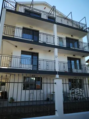 a white building with balconies and a fence at Weißer Schwan Белият лебед in Shkorpilovtsi