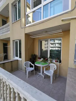 a patio with a table and chairs on a balcony at Нашето място in Pomorie