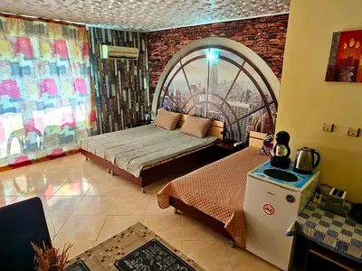 a bedroom with a bed and a large window at Курортно студио in Sunny Beach