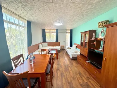 a living room with a table and a couch at Апартаменти Зафи in Sozopol