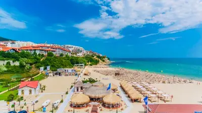 a beach with umbrellas and chairs and the ocean at Dolce Vita sea view apartment in Sveti Vlas