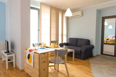 a living room with a table and a couch at Апартамент в жълто in Burgas City