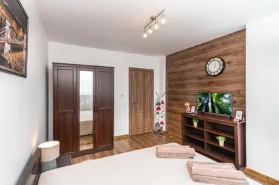 a room with a bed and a clock on a wall at Апартамент за гости ВО1 in Burgas City