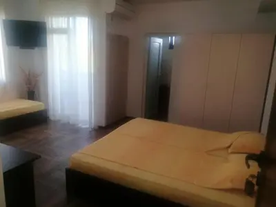 a bedroom with a bed and a window and a room at Къща за гости ЕЛИ in Primorsko