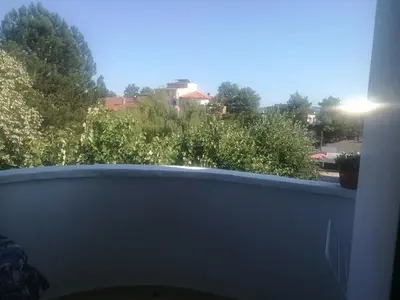a window with a view of a yard with bushes at Къща за гости ЕЛИ in Primorsko