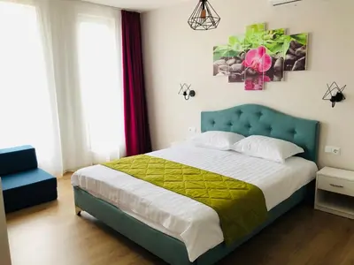 a bedroom with a large bed with a blue headboard at Colors Boutique in Obzor