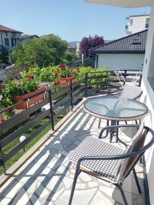 a patio with a table and chairs on a balcony at Vila Rosen in Lozenets