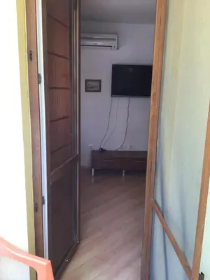 an open door to a living room with a television and a floor at SunnySeasons Apartment with swimming pool view in Byala