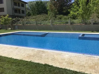 a large blue swimming pool in a yard at SunnySeasons Apartment with swimming pool view in Byala