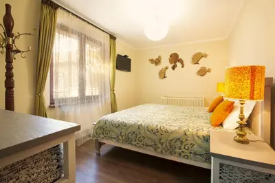 a bedroom with a bed and a lamp and a window at Guest House Soirée in Nesebar