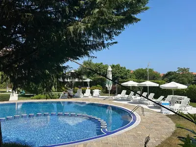 a large swimming pool with chairs and umbrellas at Sozopoli Hills Apartment A6 in Sozopol