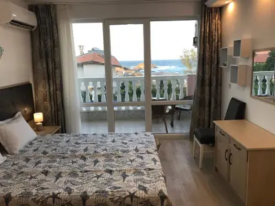 a bedroom with a bed and a view of a balcony at Студио Сънрайз А28, Лозенец in Lozenets