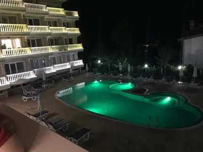 a pool in the middle of a hotel at night at Студио Сънрайз А28, Лозенец in Lozenets