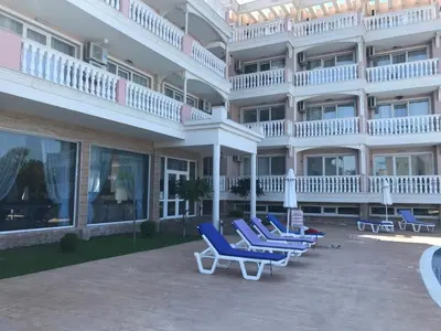 a row of blue lounge chairs in front of a building at Студио Сънрайз А28, Лозенец in Lozenets