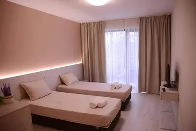 a hotel room with two beds and a window at Стаи за гости Гебедже in Beloslav