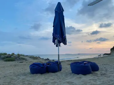 an umbrella and two blue bags on the beach at Sea View Panoramic Apartments, Fort Noks Crown Club in Sveti Vlas