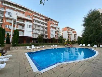 an apartment with a swimming pool in front of a building at Sea View Panoramic Apartments, Fort Noks Crown Club in Sveti Vlas