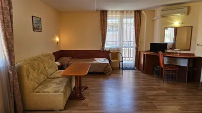 a living room with a couch and a table at Caprice Family Hotel in Varna City