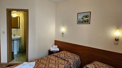 a hotel room with two beds and a sink at Caprice Family Hotel in Varna City