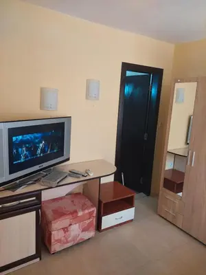 a living room with a tv and a table and a door at Femili Hotel Diveda in Sveti Vlas
